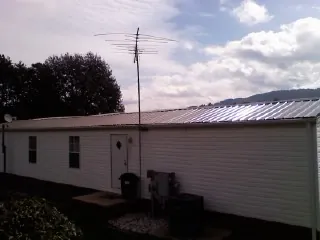 New metal roof on a single wide mobile home with a TV antenna in Sunbury