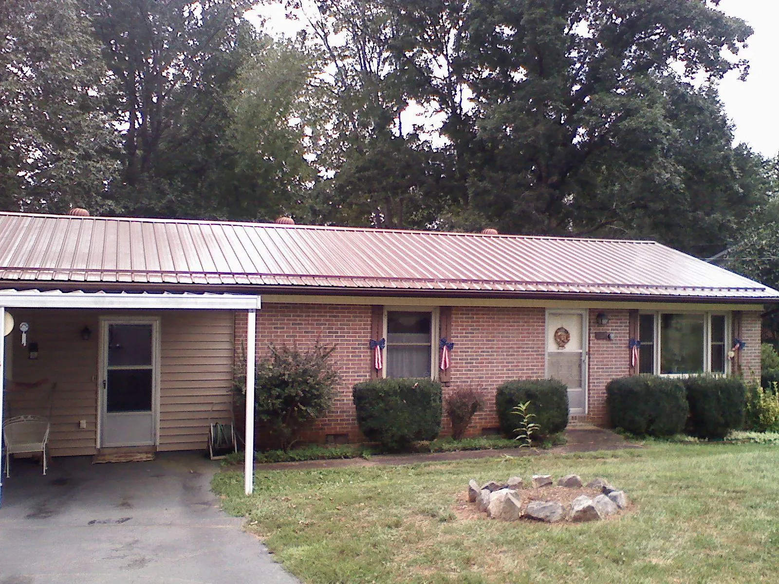 Bronze metal roof and carport on a brick ranch home — Roof Repair work by our crew in Sunbury